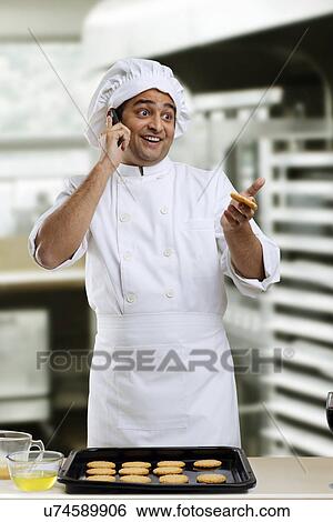 Stock Photograph - Chef talking on a mobile phone . Fotosearch