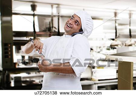 Stock Photo - Chef talking on a mobile phone while beating dough . Fotosearch