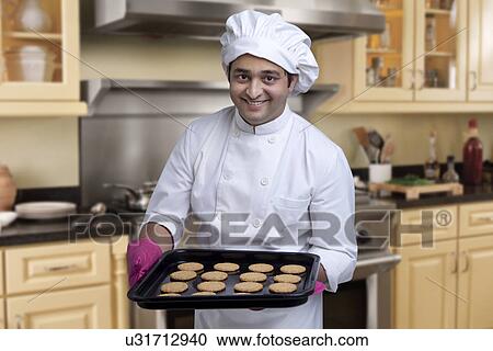 Chef with a tray of baked cookies View Large Photo Image Stock Image - Chef with a tray of baked cookies . Fotosearch