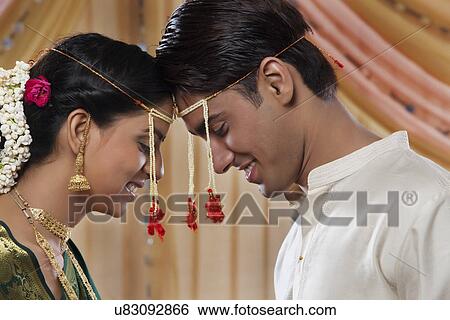 Stock Photograph - Close-up of smiling bride and groom looking at each other . Fotosearch