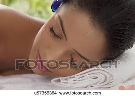 Close-up of woman relaxing her head on towel View Large Photo Image Picture - Close-up of woman relaxing her head on towel . Fotosearch