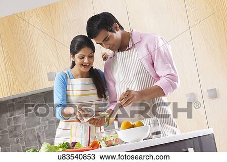 Couple adding salt to vegetable salad in kitchen View Large Photo Image Stock Image - Couple adding salt to vegetable salad in kitchen. Fotosearch