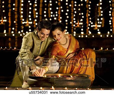 Couple arranging diyas View Large Photo Image Stock Image - Couple arranging diyas . Fotosearch