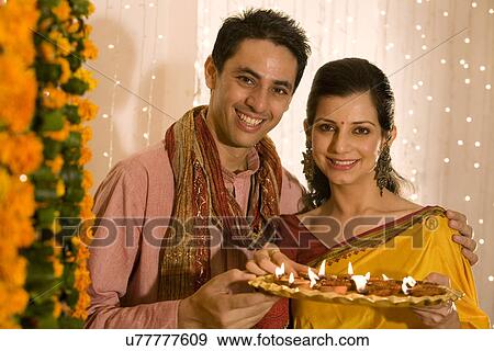 Couple holding a tray of diyas View Large Photo Image Stock Photo - Couple holding a tray of diyas . Fotosearch