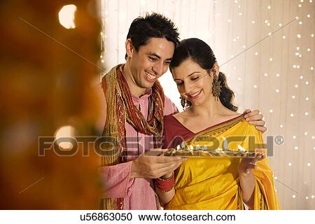 Couple holding a tray with diyas View Large Photo Image Stock Image - Couple holding a tray with diyas . Fotosearch