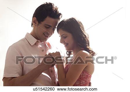 Couple holding each other while looking at ring View Large Photo Image Stock Image - Couple holding each other while looking at ring. Fotosearch