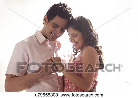 Couple holding each other while looking at ring View Large Photo Image Stock Photo - Couple holding each other while looking at ring. Fotosearch