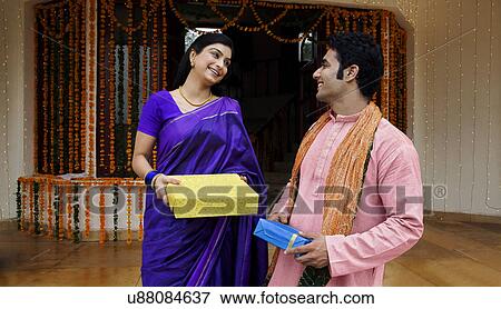 Stock Photo - Couple holding gifts . Fotosearch