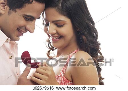 Couple looking at engagement ring View Large Photo Image Stock Photograph - Couple looking at engagement ring. Fotosearch