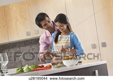 Couple preparing vegetable salad together in kitchen View Large Photo Image Picture - Couple preparing vegetable salad together in kitchen. Fotosearch