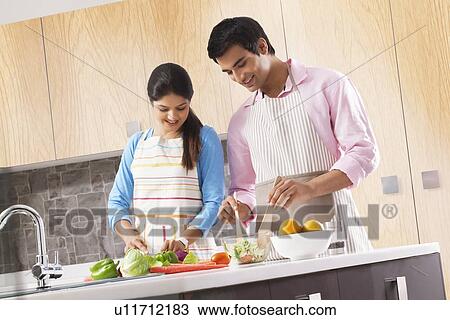 Couple preparing vegetable salad together in kitchen View Large Photo Image Stock Image - Couple preparing vegetable salad together in kitchen. Fotosearch