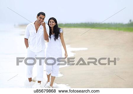 Couple walking on a beach View Large Photo Image Stock Photo - Couple walking on a beach . Fotosearch