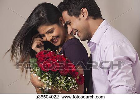 Couple with a bouquet of roses smiling View Large Photo Image Stock Image - Couple with a bouquet of roses smiling. Fotosearch