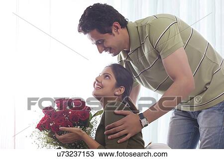 Couple with a bouquet of roses smiling View Large Photo Image Stock Image - Couple with a bouquet of roses smiling. Fotosearch