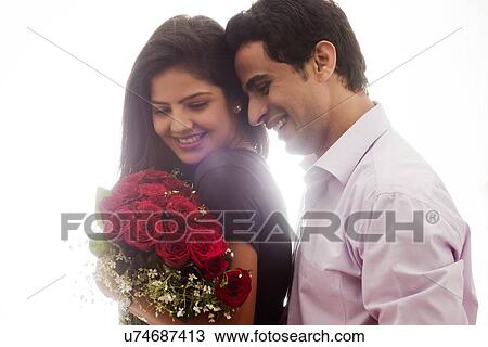 Couple with a bouquet of roses smiling View Large Photo Image Stock Image - Couple with a bouquet of roses smiling. Fotosearch