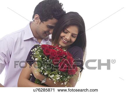 Stock Image - Couple with a bouquet of roses smiling. Fotosearch