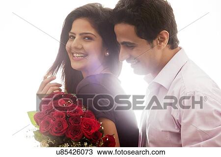 Couple with a bouquet of roses smiling View Large Photo Image Stock Image - Couple with a bouquet of roses smiling. Fotosearch