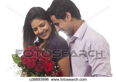 Couple with a bouquet of roses smiling View Large Photo Image Stock Photograph - Couple with a bouquet of roses smiling. Fotosearch