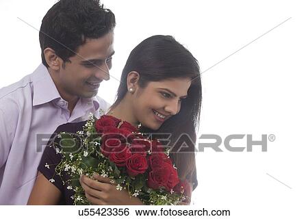 Couple with a bouquet of roses smiling View Large Photo Image Stock Photograph - Couple with a bouquet of roses smiling. Fotosearch