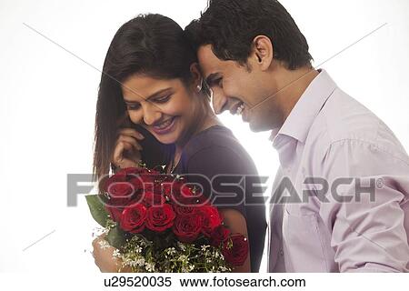 Stock Photography - Couple with a bouquet of roses smiling. Fotosearch