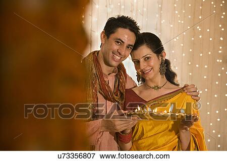 Stock Photo - Couple with a tray of diyas . Fotosearch