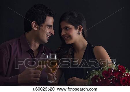 Stock Image - Couple with glasses of wine on Valentines Day. Fotosearch