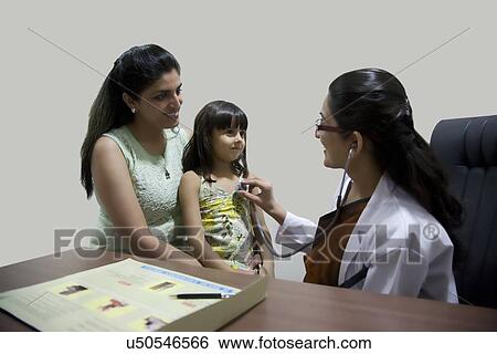Doctor checking a girl's heartbeat View Large Photo Image Stock Photograph - Doctor checking a girl's heartbeat . Fotosearch