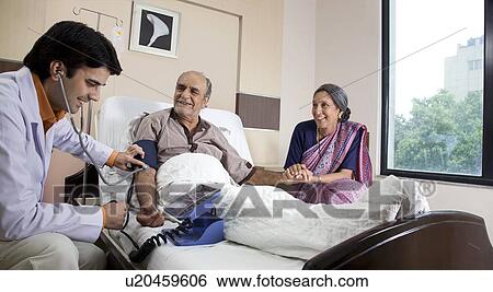 Stock Photograph - Doctor checking a patient's blood pressure . Fotosearch