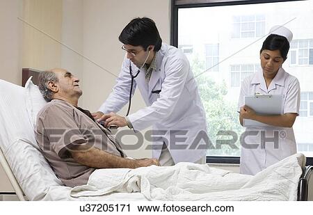 Stock Image - Doctor checking a patient's heartbeat . Fotosearch