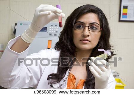 Doctor looking at a blood sample View Large Photo Image Stock Photo - Doctor looking at a blood sample . Fotosearch