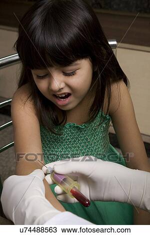 Stock Image - Doctor taking a blood sample from a girl . Fotosearch