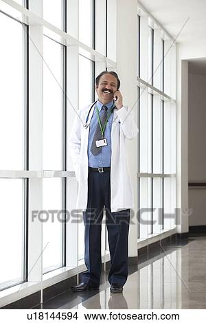 Picture - Doctor talking on a mobile phone. Fotosearch