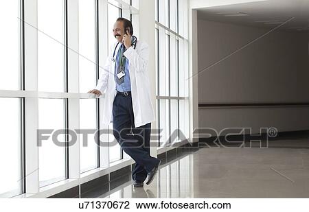 Doctor talking on a mobile phone View Large Photo Image Stock Image - Doctor talking on a mobile phone. Fotosearch