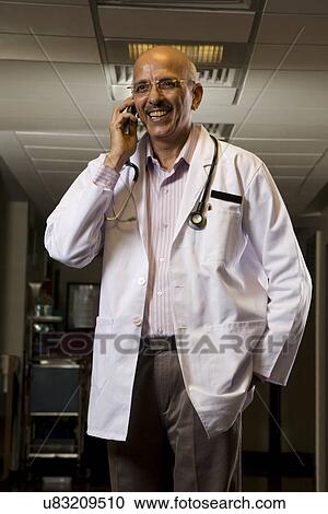 Doctor talking on a mobile phone View Large Photo Image Stock Image - Doctor talking on a mobile phone . Fotosearch