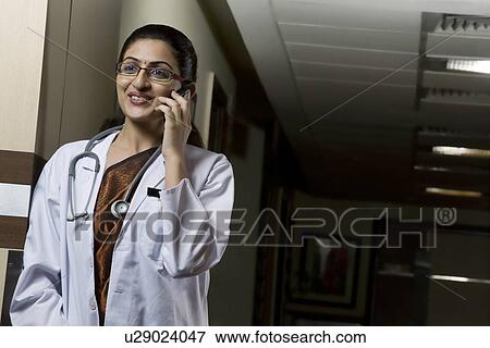 Stock Photo - Doctor talking on a mobile phone . Fotosearch