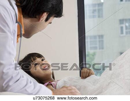 Doctor talking to a little girl View Large Photo Image Stock Photo - Doctor talking to a little girl . Fotosearch