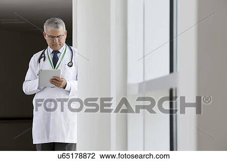 Doctor with a digital tablet View Large Photo Image Stock Image - Doctor with a digital tablet. Fotosearch