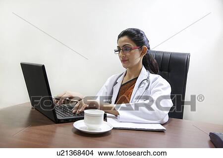 Picture - Doctor working on a laptop . Fotosearch