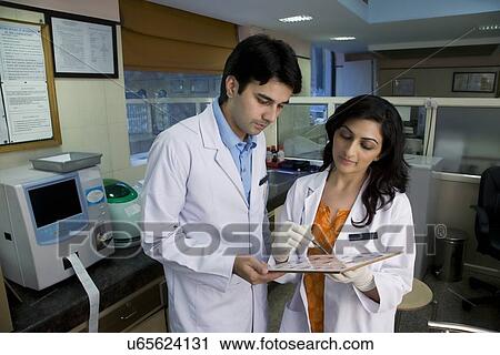 Doctors looking at a report  View Large Photo Image Stock Image - Doctors looking at a report . Fotosearch