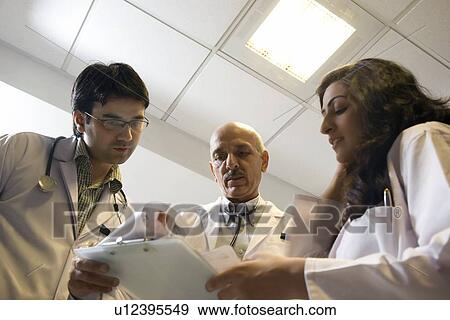 Stock Photo - Doctors looking at a report . Fotosearch
