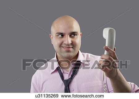 Executive holding a telephone View Large Photo Image Stock Photo - Executive holding a telephone . Fotosearch