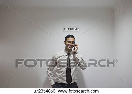 Executive talking on a mobile phone in a non-speaking zone View Large Photo Image Stock Image - Executive talking on a mobile phone in a non-speaking zone. Fotosearch