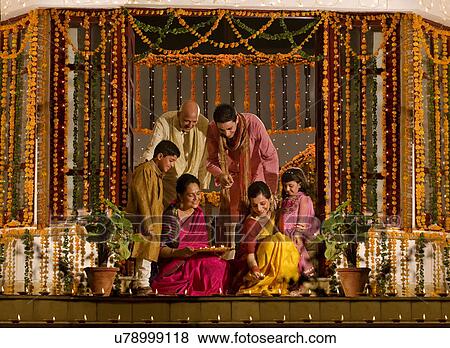 Stock Photo - Family arranging diyas . Fotosearch