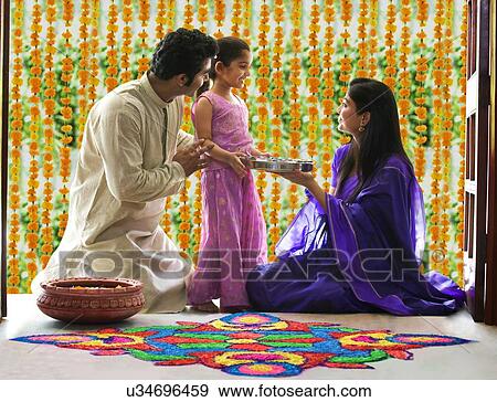 Stock Photo - Family making a rangoli . Fotosearch