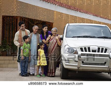 Stock Image - Family standing next to a car . Fotosearch