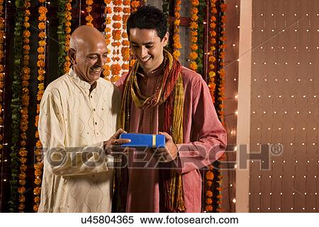 Father giving his son a gift View Large Photo Image Stock Photography - Father giving his son a gift . Fotosearch