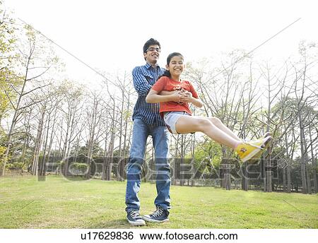 Father swinging his daughter around View Large Photo Image Stock Photograph - Father swinging his daughter around . Fotosearch