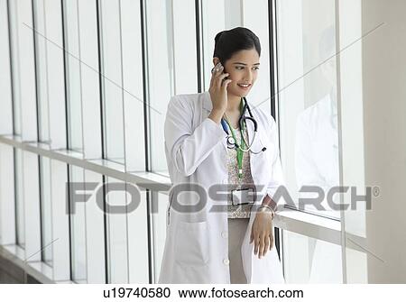 Female doctor talking on a mobile phone View Large Photo Image Stock Image - Female doctor talking on a mobile phone. Fotosearch