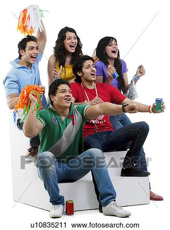Friends cheering while watching a cricket match View Large Photo Image Stock Image - Friends cheering while watching a cricket match . Fotosearch