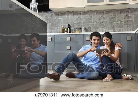 Full length of couple using digital tablet together in kitchen View Large Photo Image Stock Image - Full length of couple using digital tablet together in kitchen. Fotosearch